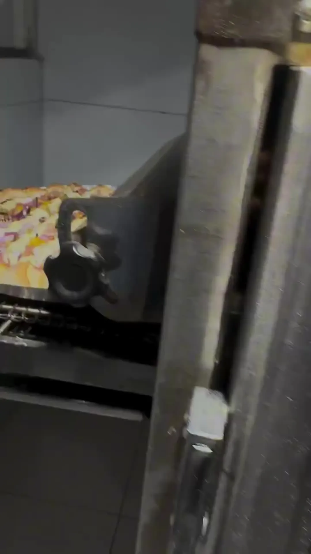 Pizza saindo do forno de esteira do Point da Pizza