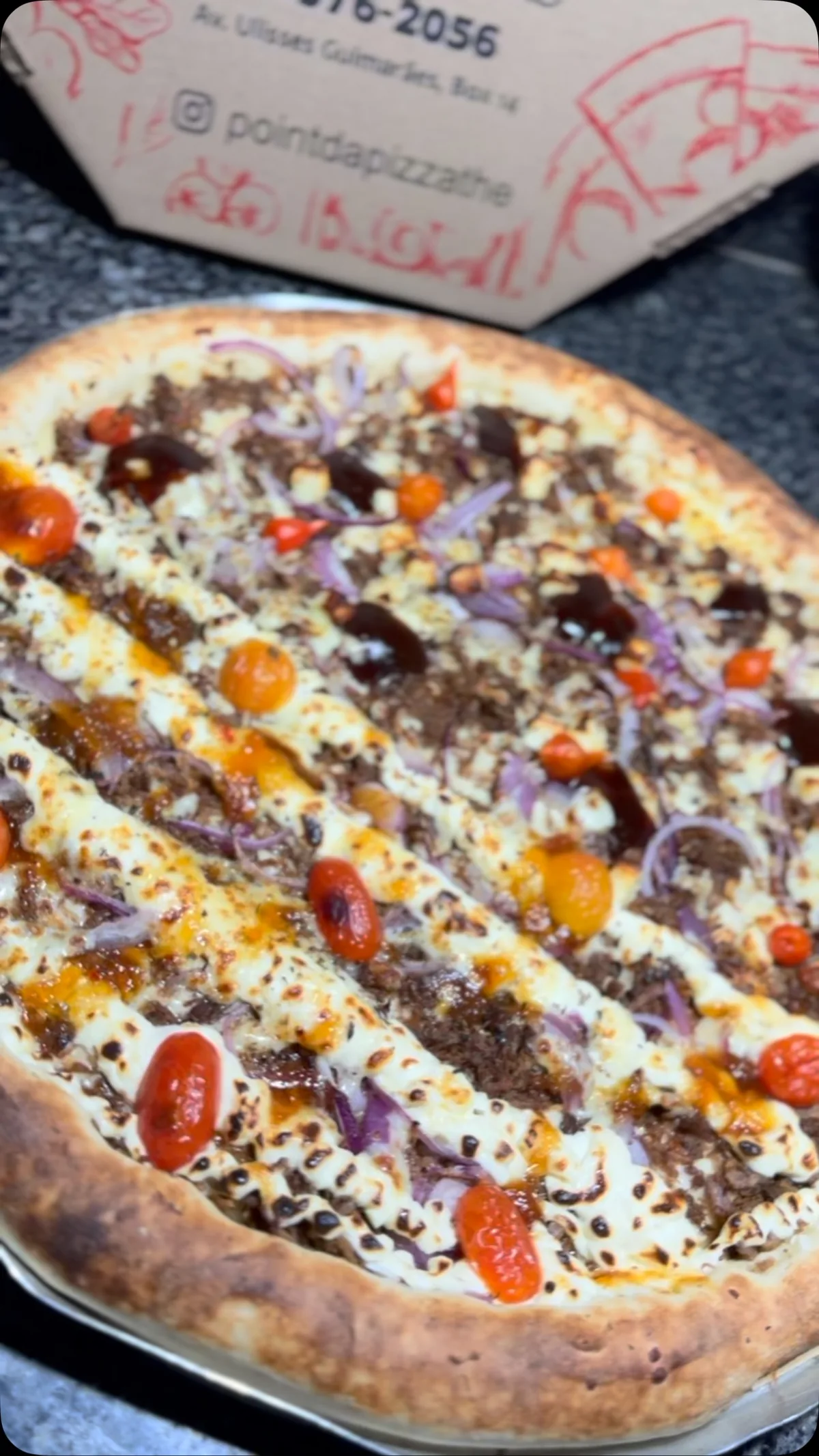 Pizza aberta na caixa com a marca do Point da Pizza