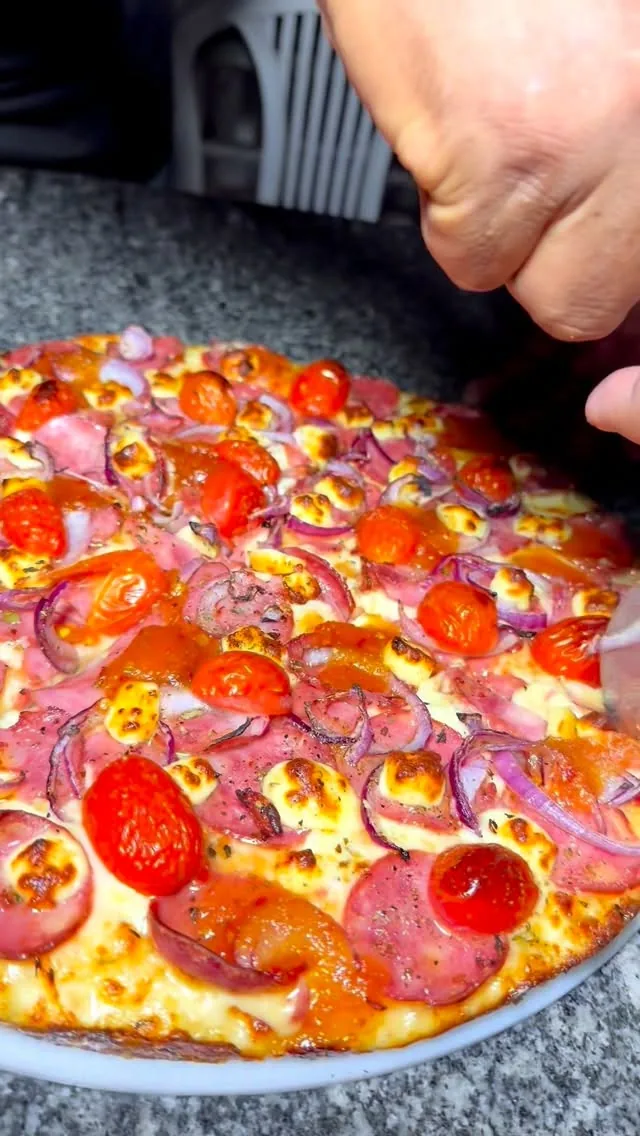 Pizza de calabresa do Point da Pizza com fatia sendo levantada